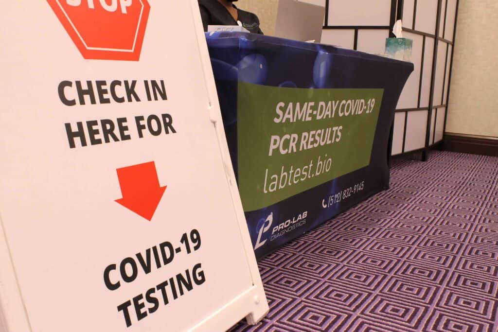A sign reading check in here for COVID-19 testing